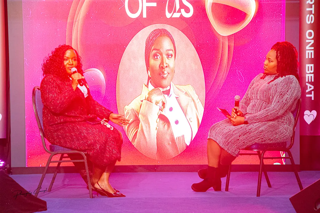 A conversation on stage beneath the portrait screen