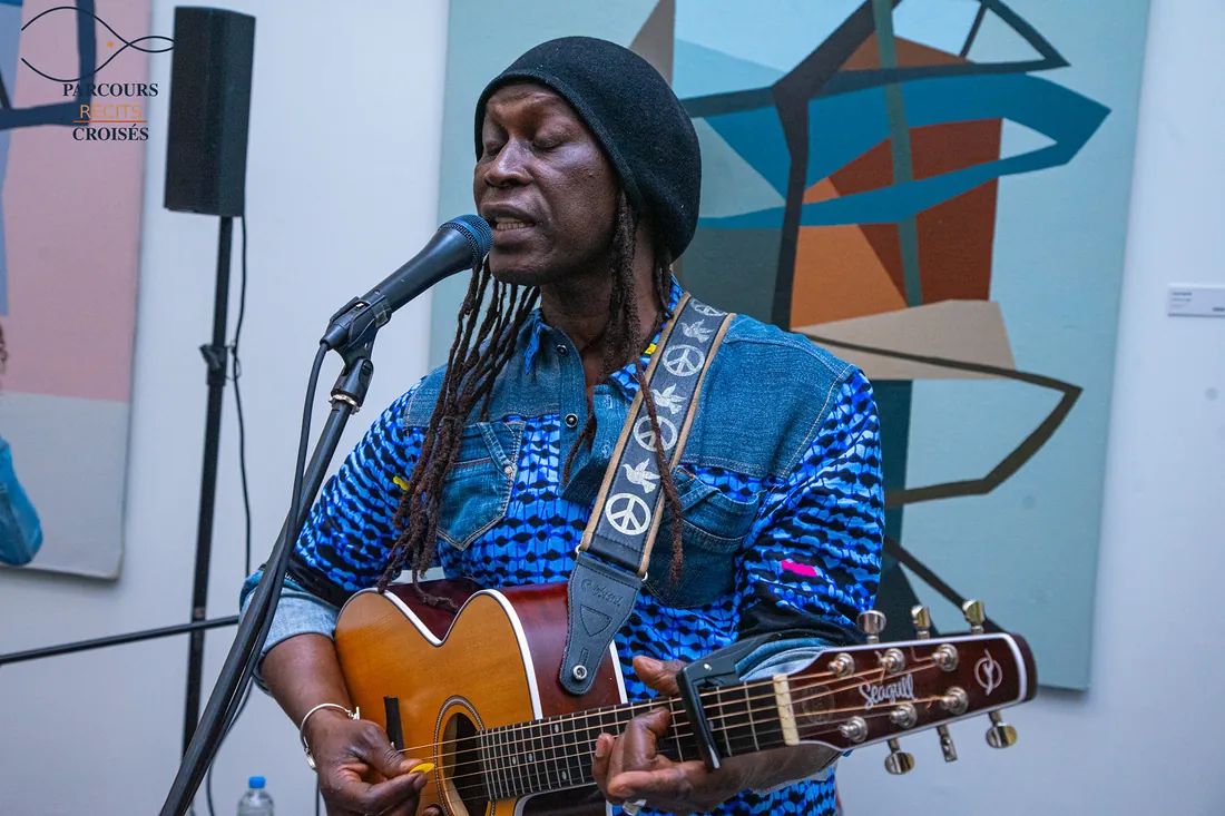 Un guitariste chante entre les tableaux